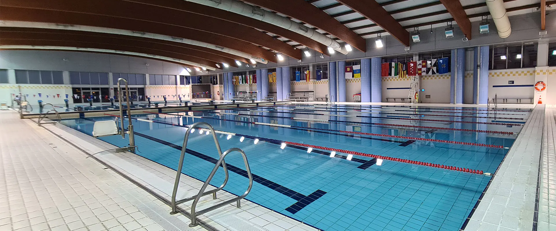 Vista lateral de la piscina olímpica, con detalle de la barandilla de acceso