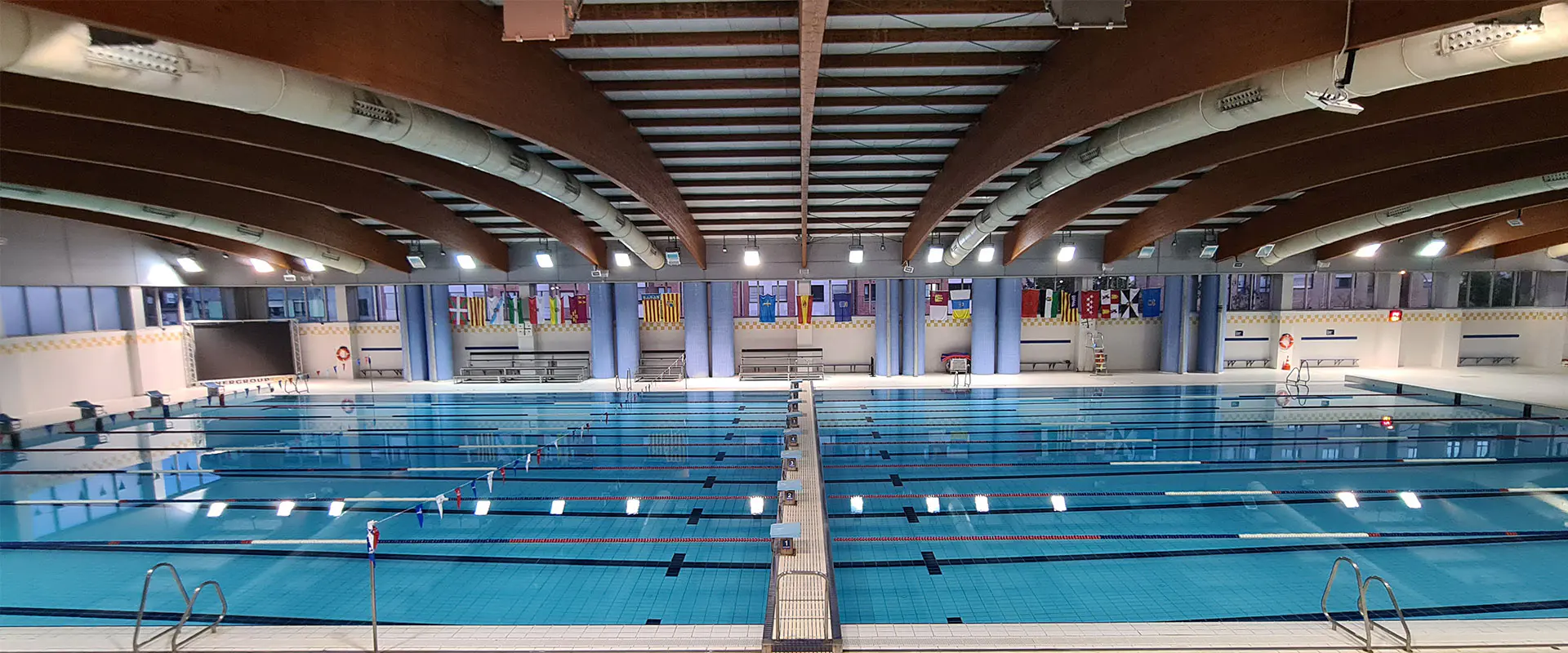 Panorámica lateral de la piscina olímpica. Puente móvil en el centro