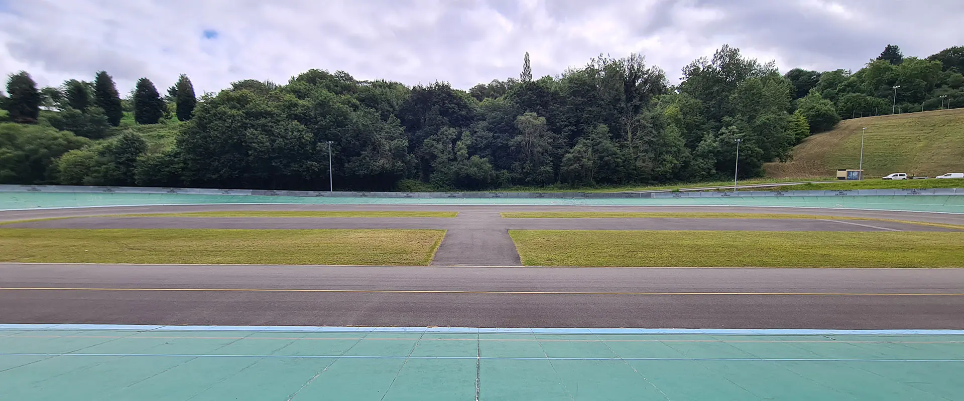 Vista a pie de pista del velódromo, con las zonas verdes circundantes al fondo