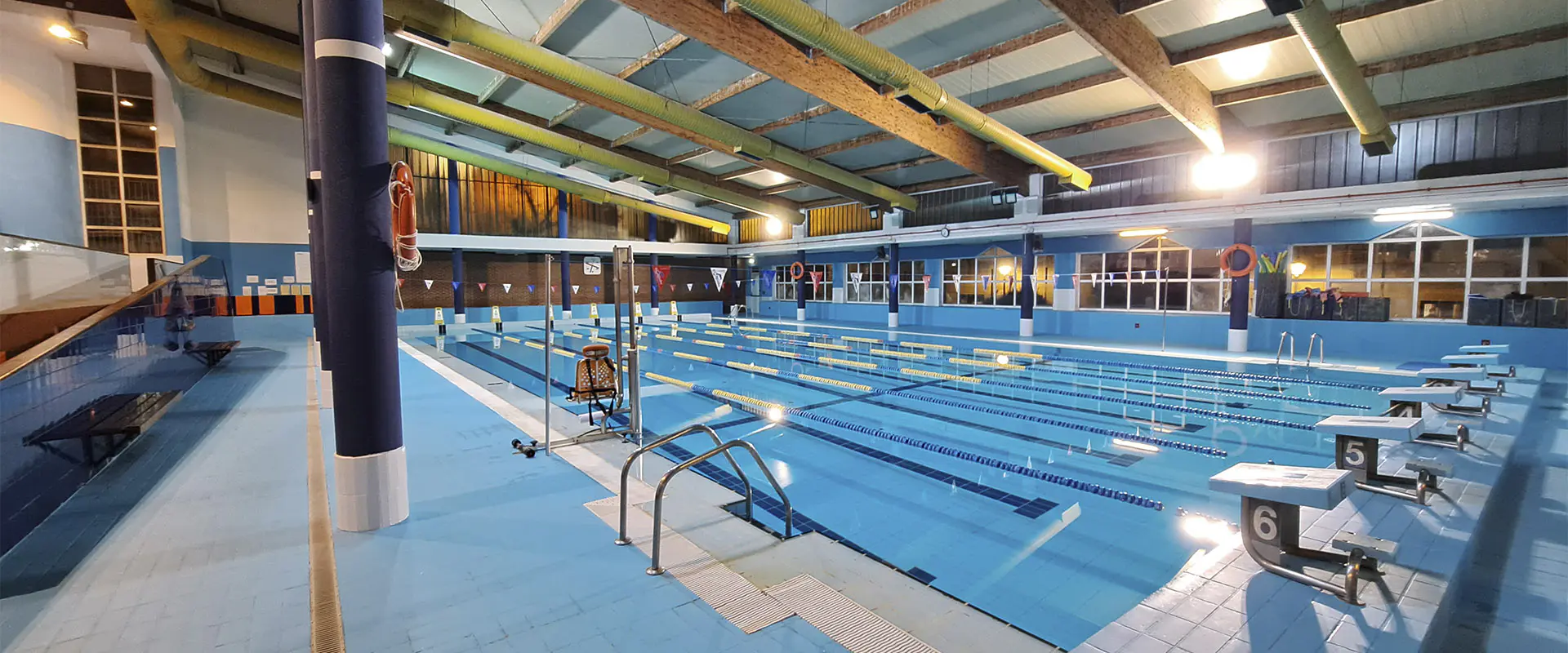 Piscina del centro deportivo, con vista en detalle de las plataformas de salida y las barandillas de acceso
