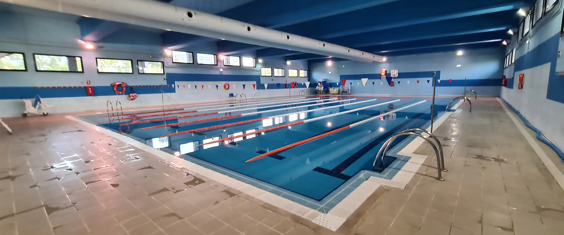 Panorámica lateral de la piscina principal, con vista en detalle de las barandillas de acceso
