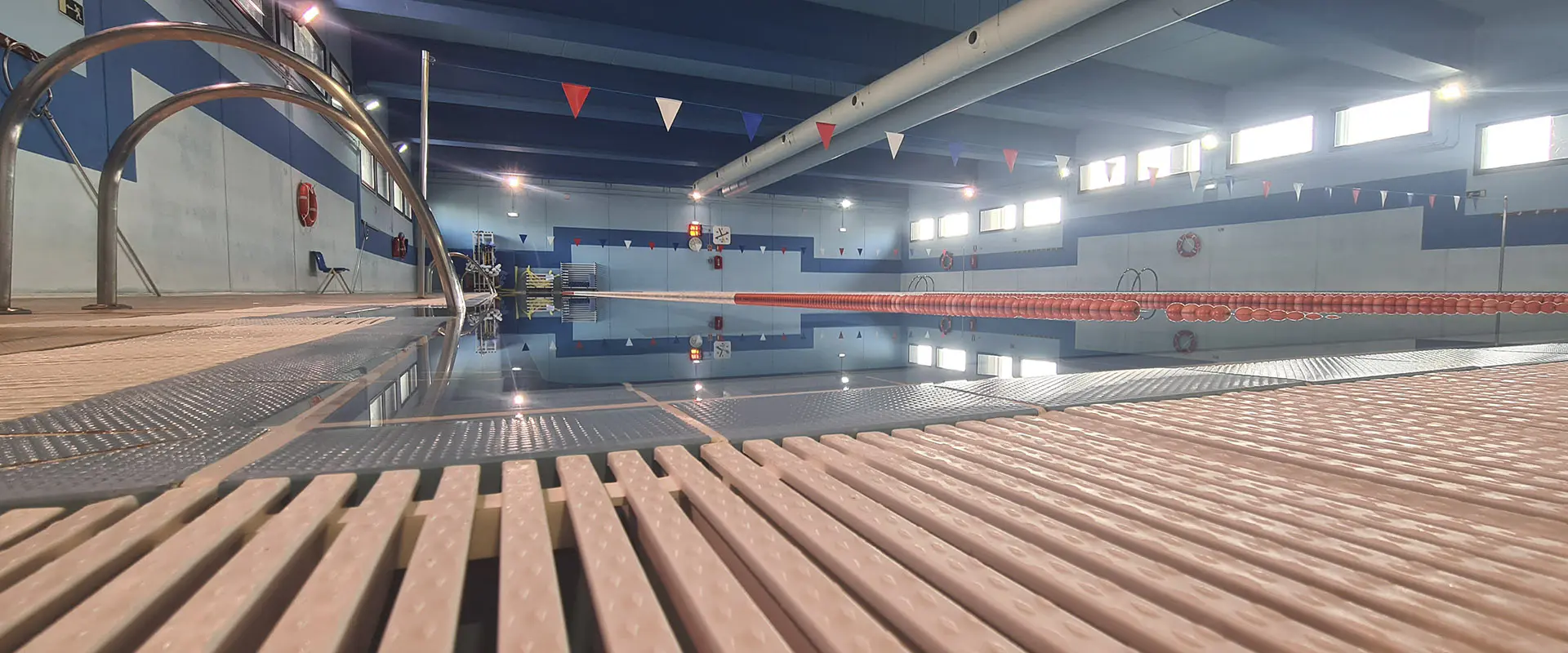 Vista a ras de suelo de la piscina principal, con detalle de los suelos de tarima de madera