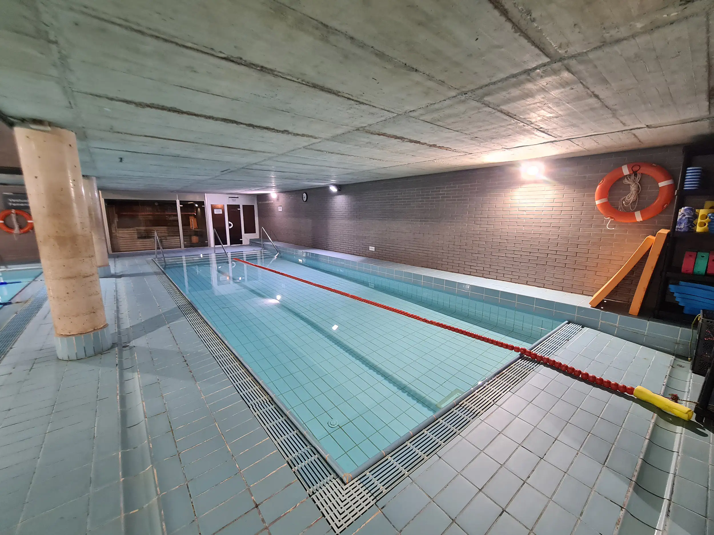 Piscina de aprendizaje climatizada, con una cuerda de seguridad y diversos accesorios de baño
