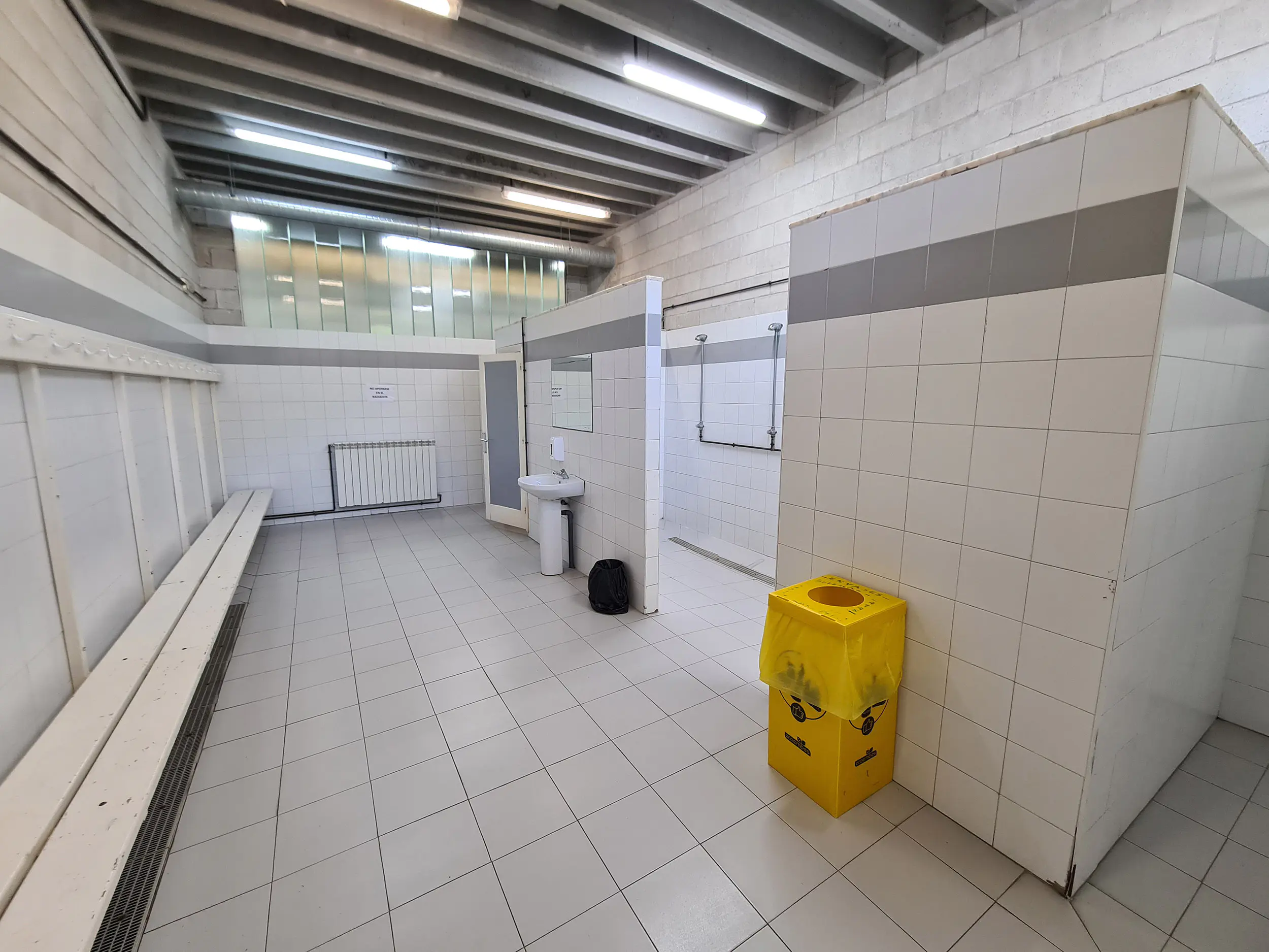 Vestuario y acceso a las duchas. Banco del mismo y acceso a la zona de duchas