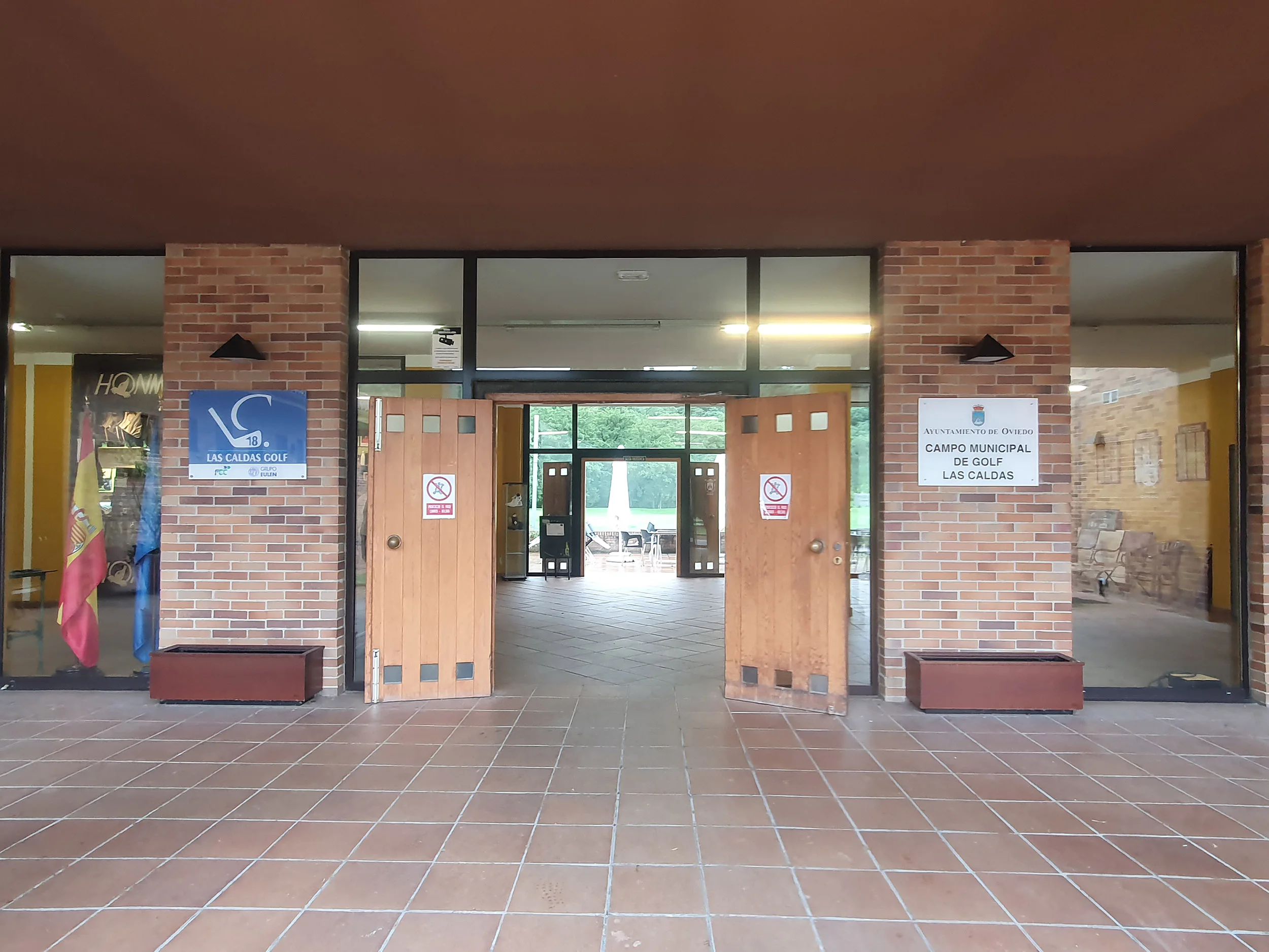 Acceso al edificio principal, con grandes puertas de madera y cristaleras