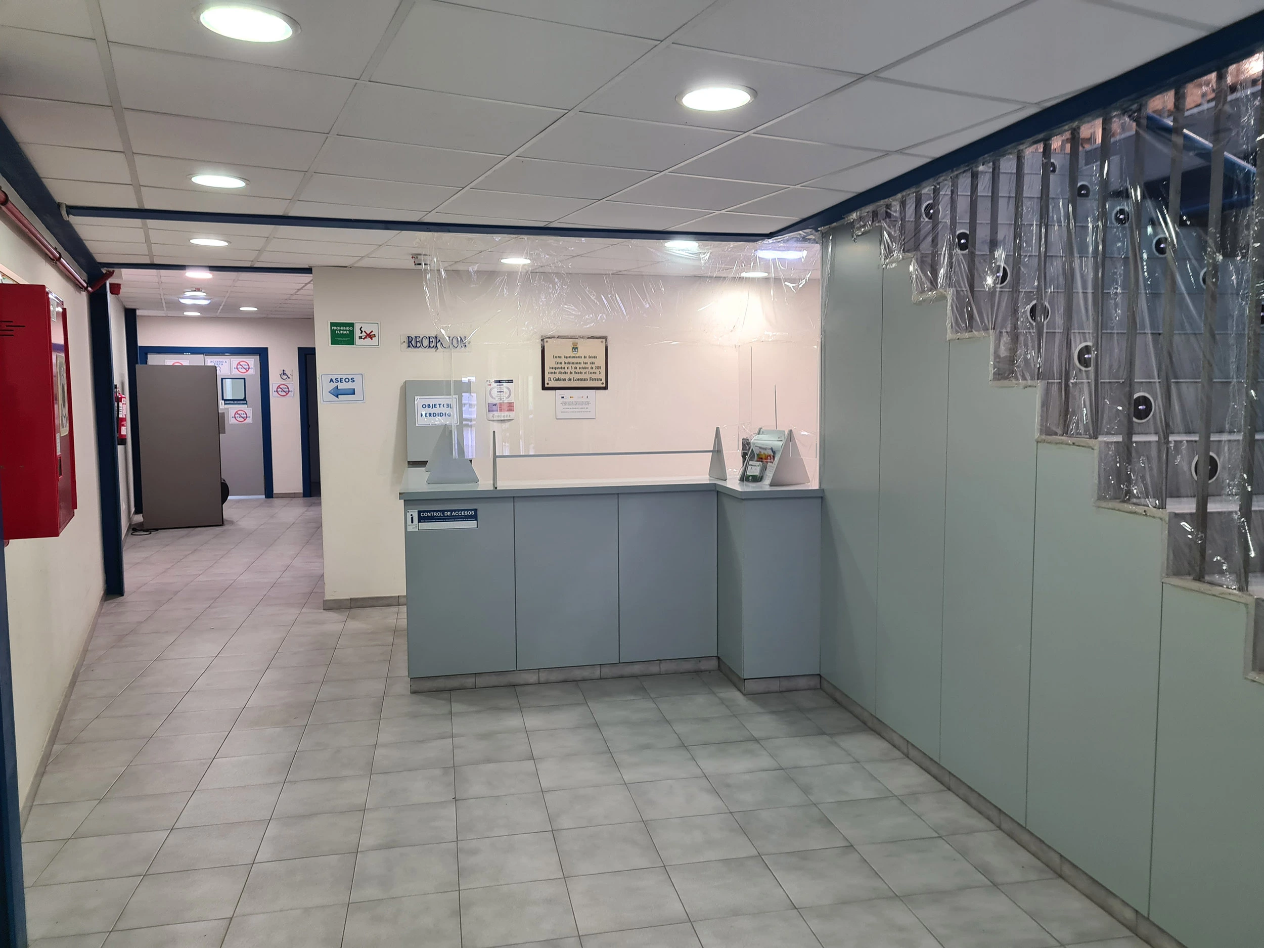 Mostrador de recepción. Escalera para subir a las gradas y pasillo a zona de vestuarios