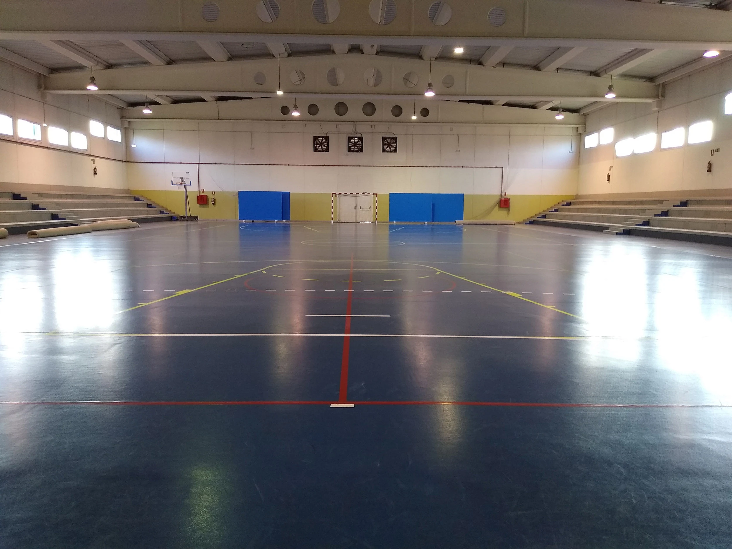 Panorámica de la pista central, con portería de fútbol sala al fondo y gradas en los laterales