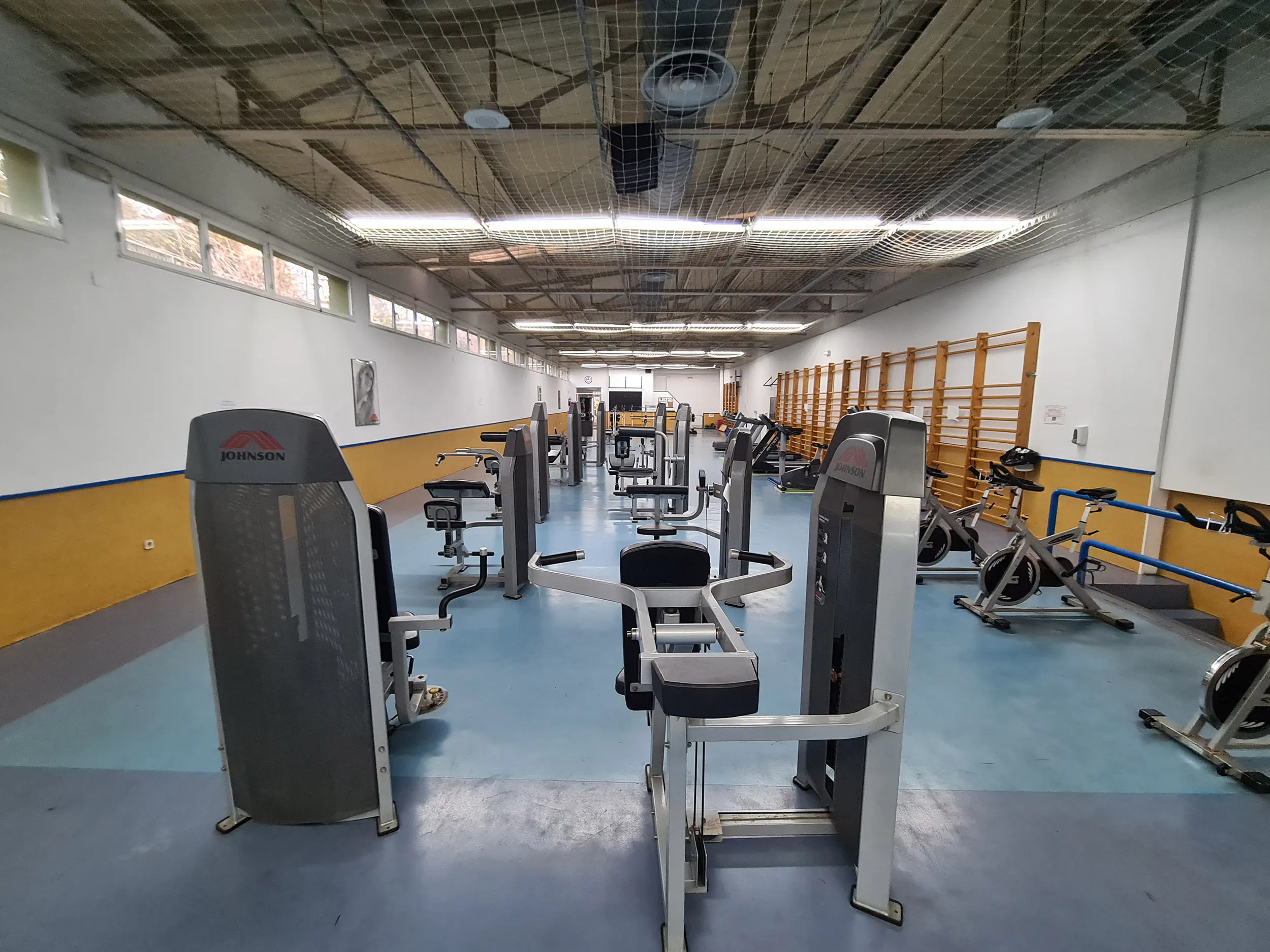 Vista del gimnasio, con bicicletas estáticas y bancos de musculación