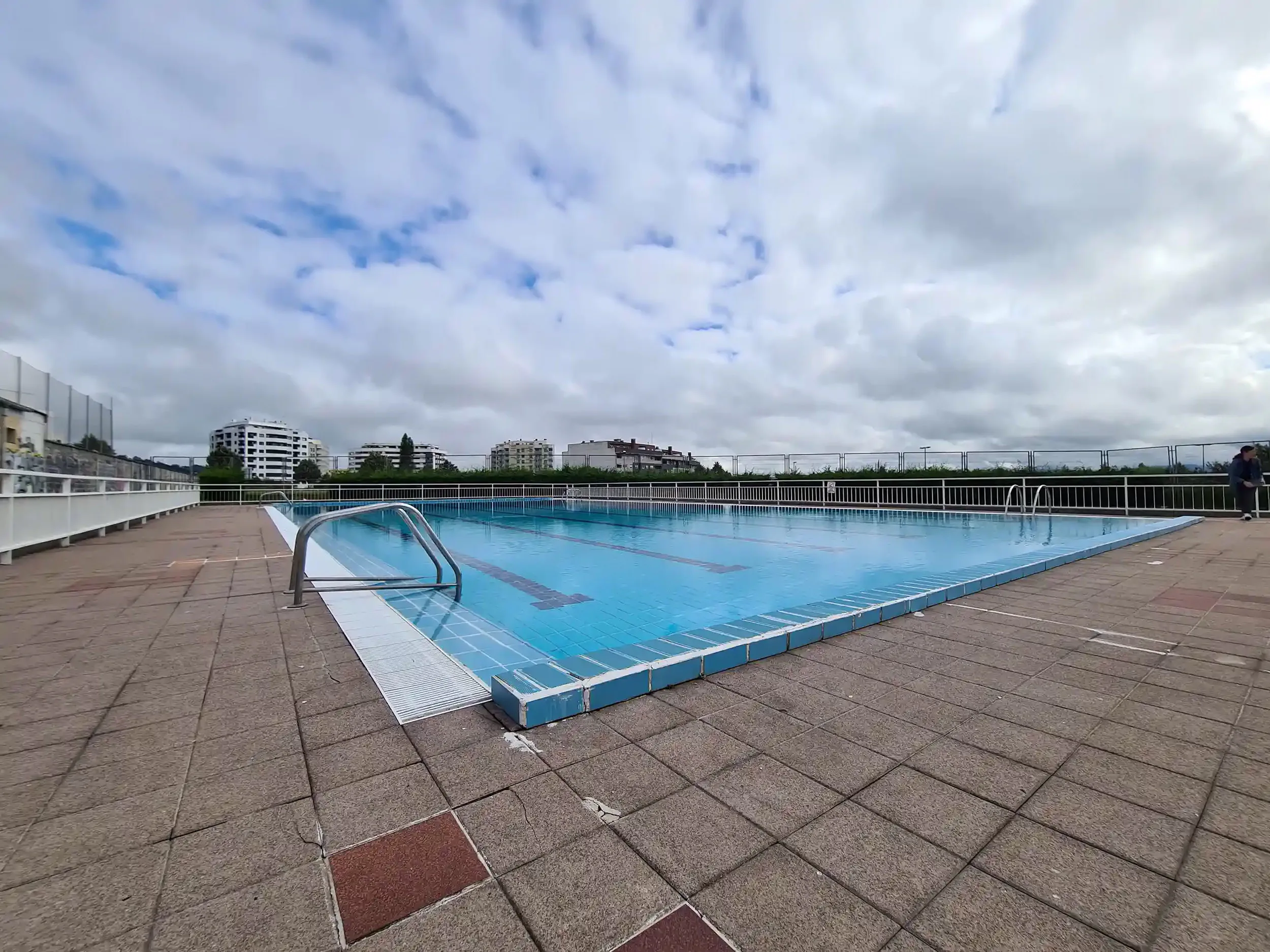 Piscina principal de La Monxina, con detalle del piso de hormigón y las barandillas de acceso