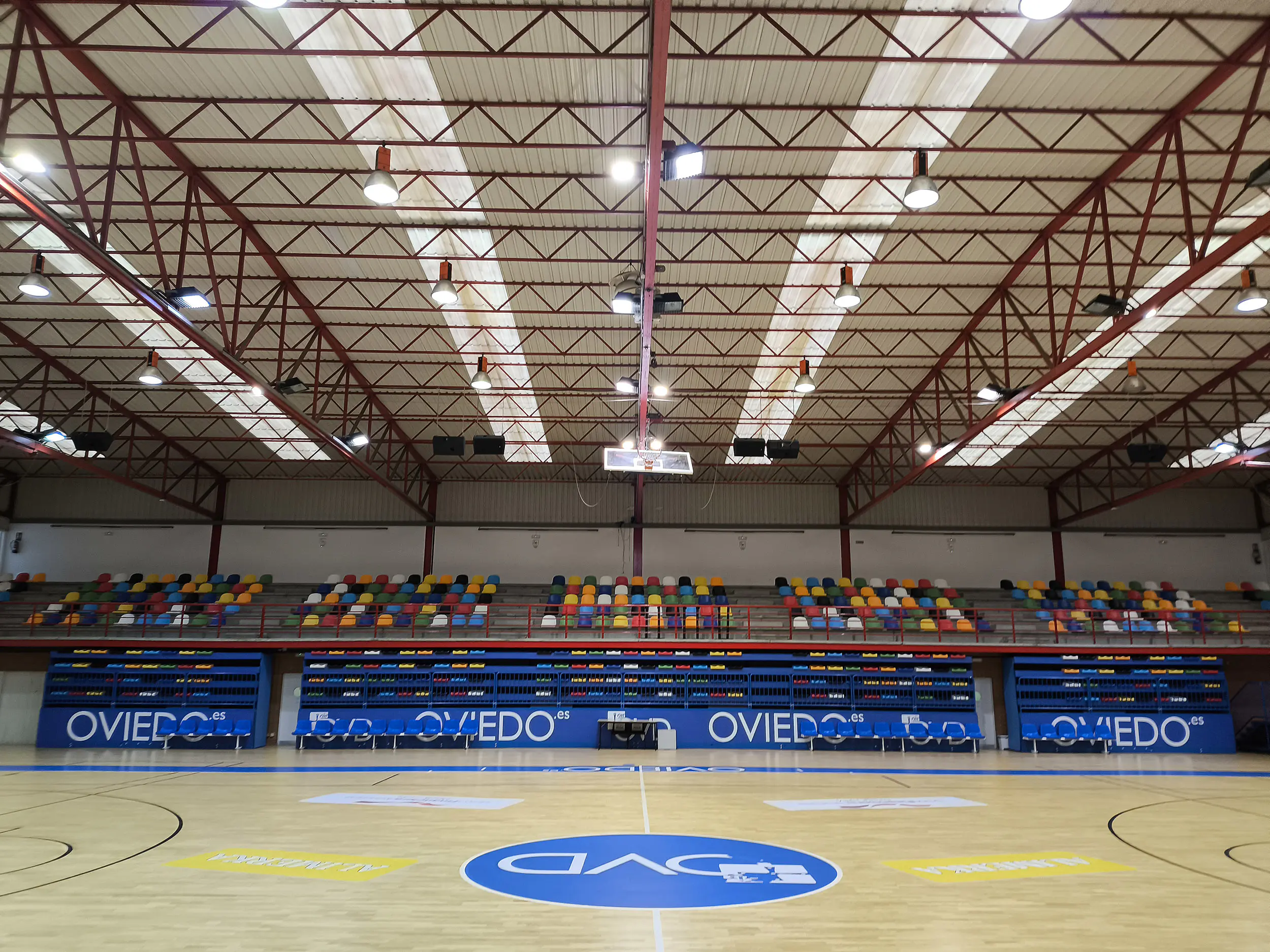 Gradas superiores fijas y extensibles inferiores. Parte de la pista polideportiva