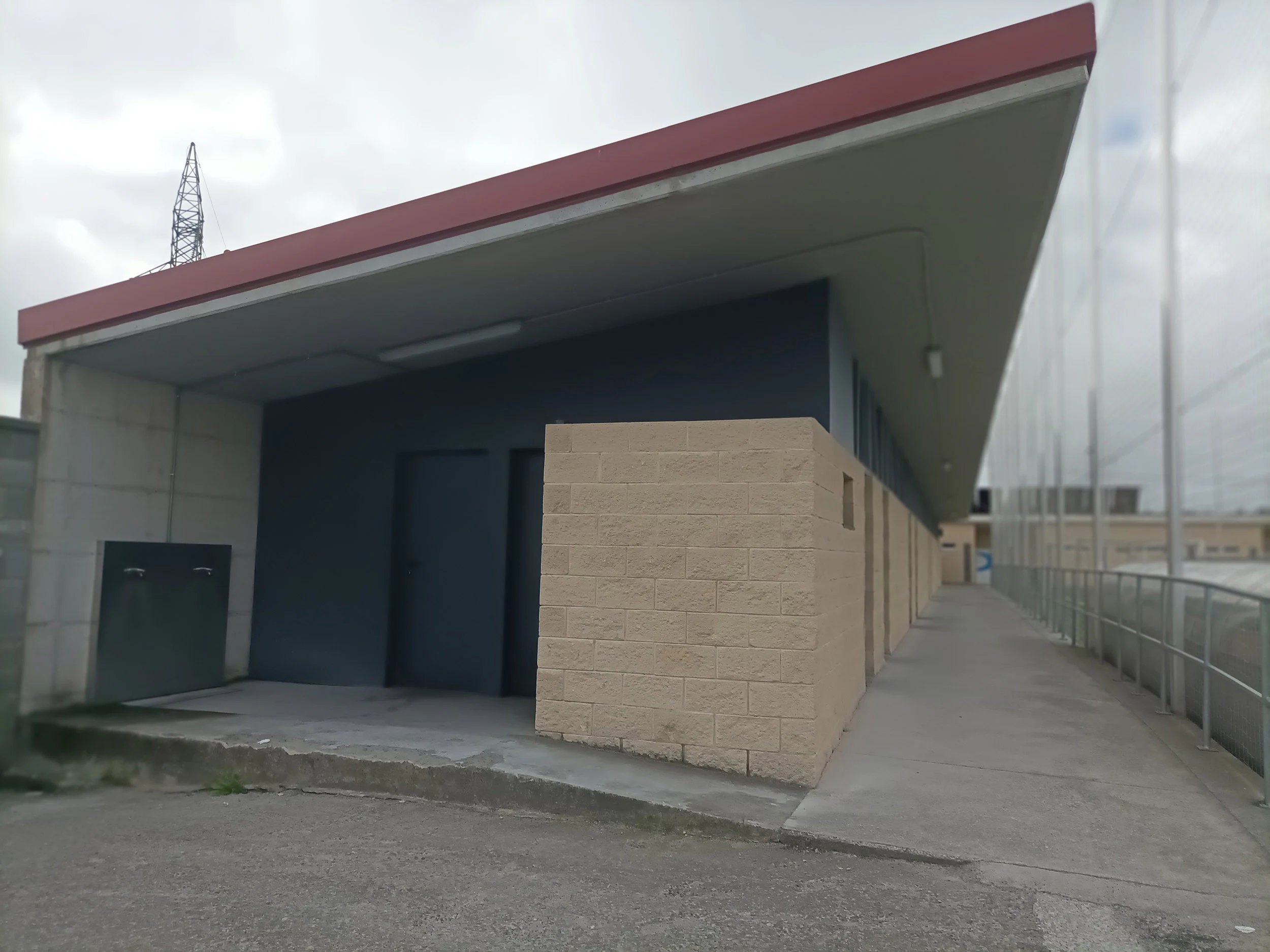 Zona lateral campo de fútbol. Vista edificio junto a un pasillo largo con acceso a vestuarios y demás instalaciones