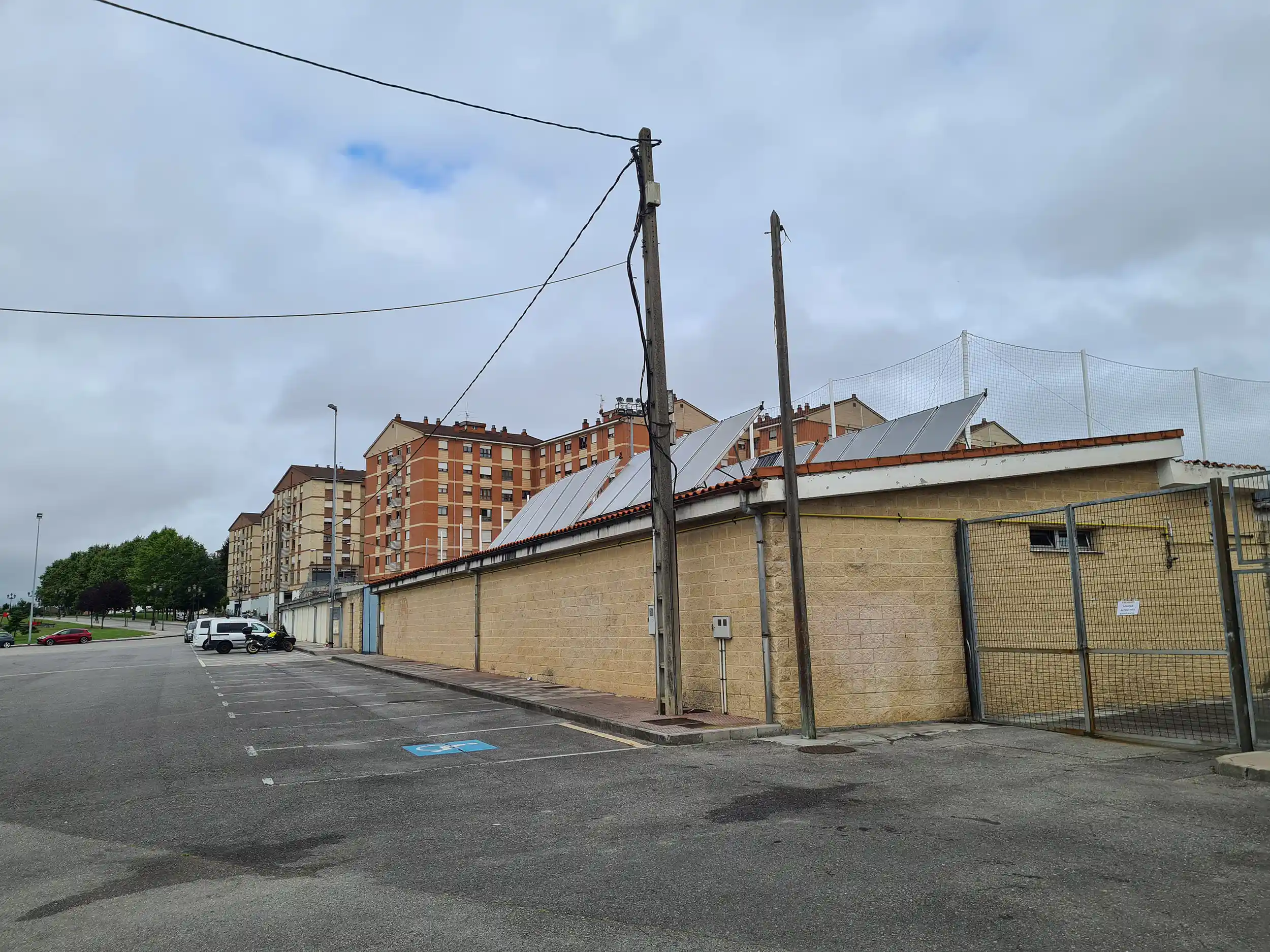 Exterior del campo de fútbol. Vista de las plazas del parking en batería y una reservada a minusválidos 