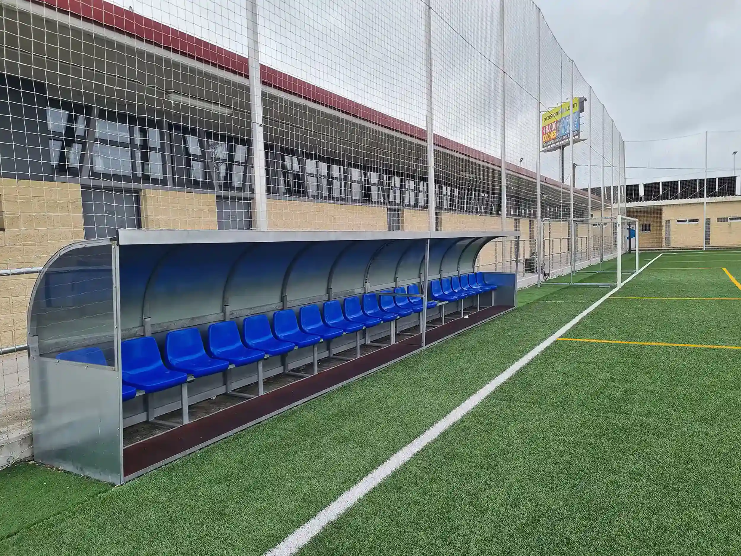 Perfil banquillo de suplentes con cubierta metálica y asientos azules para los jugadores y el equipo técnico