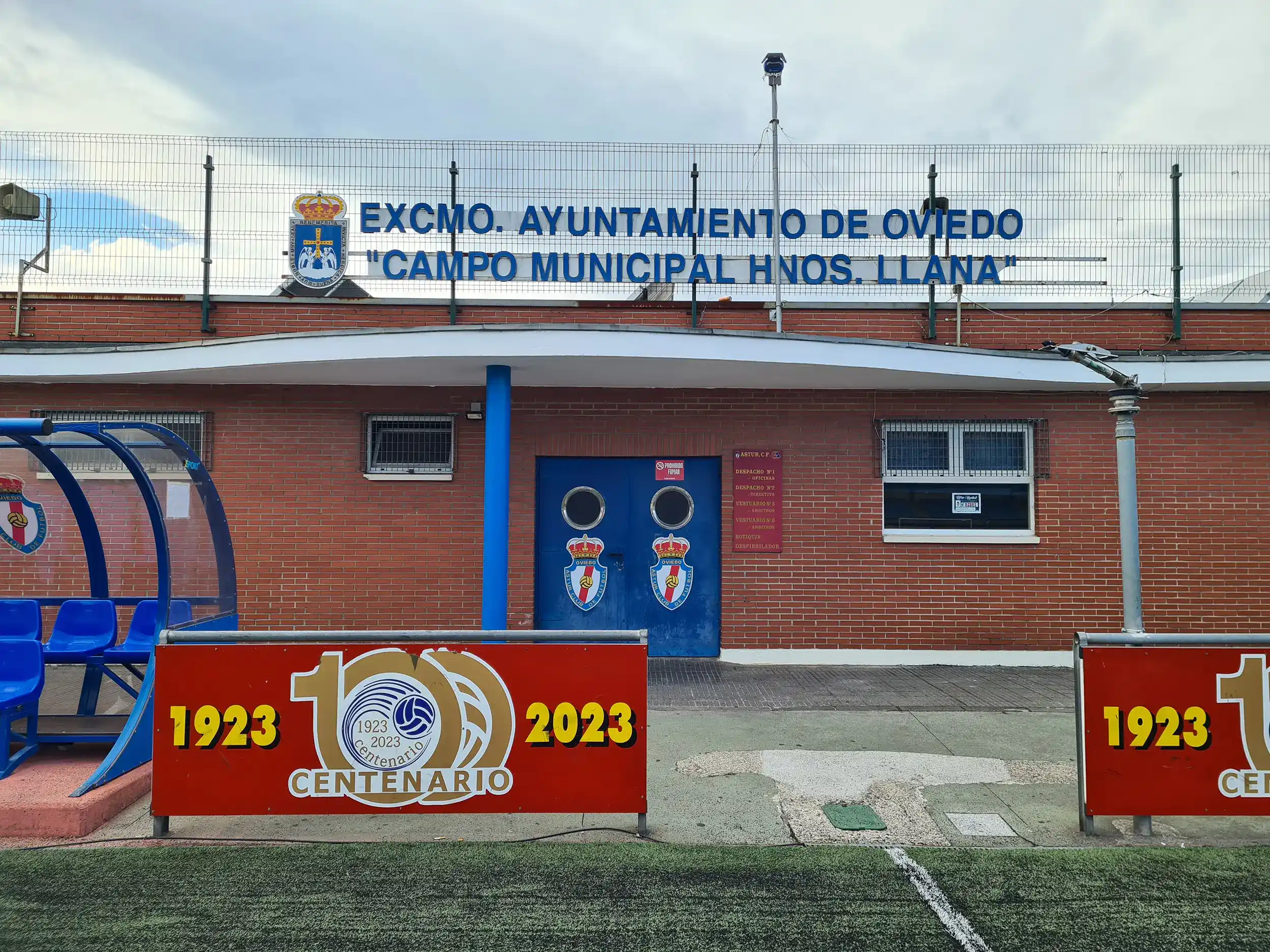 Fachada de un edificio de servicios, con letrero en la parte superior con el nombre de la instalación y el escudo de Oviedo