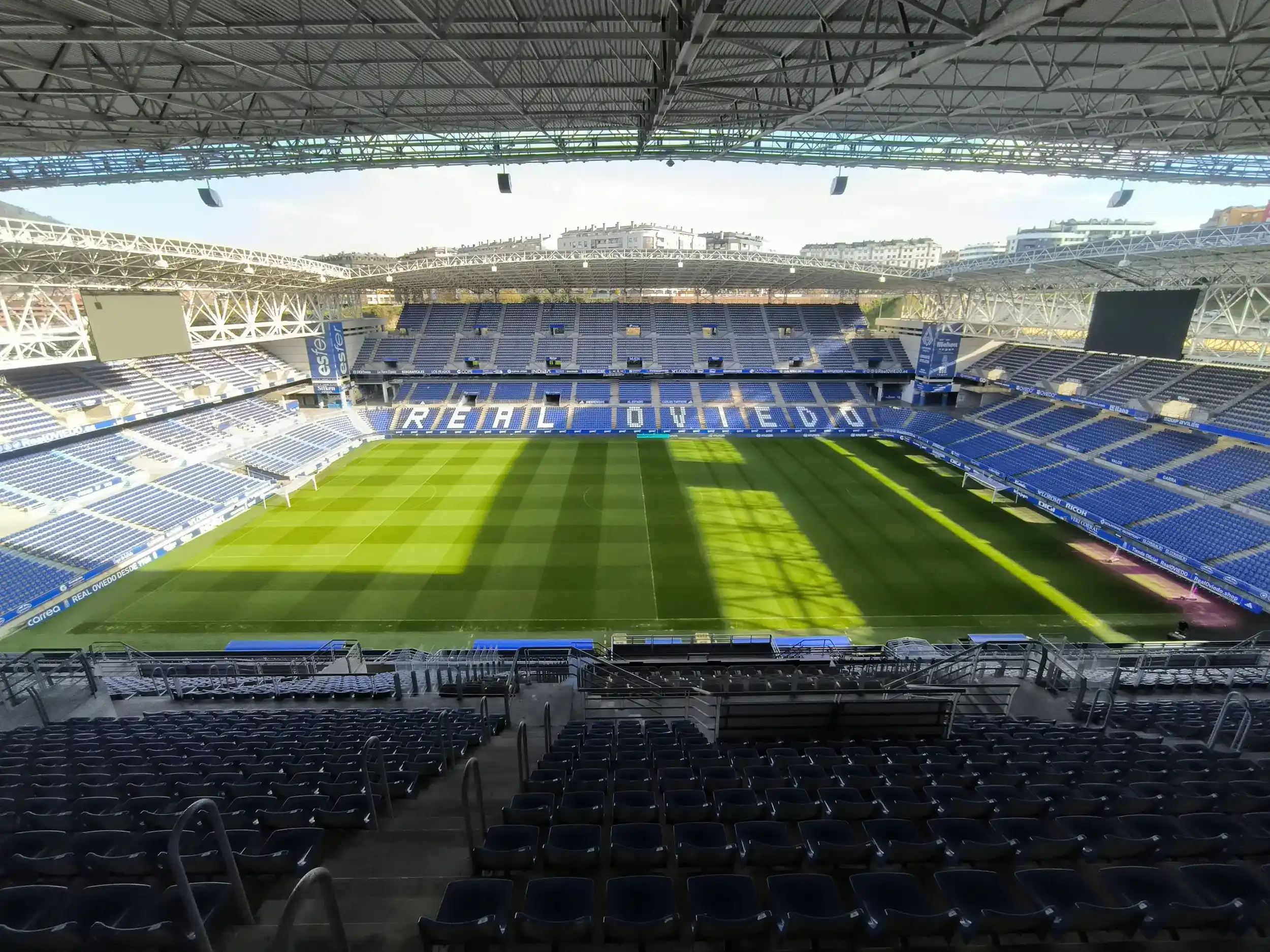 Campo de juego y tribunas desde interior grada. De frente en el anillo azul destaca en letras blancas: Real Oviedo