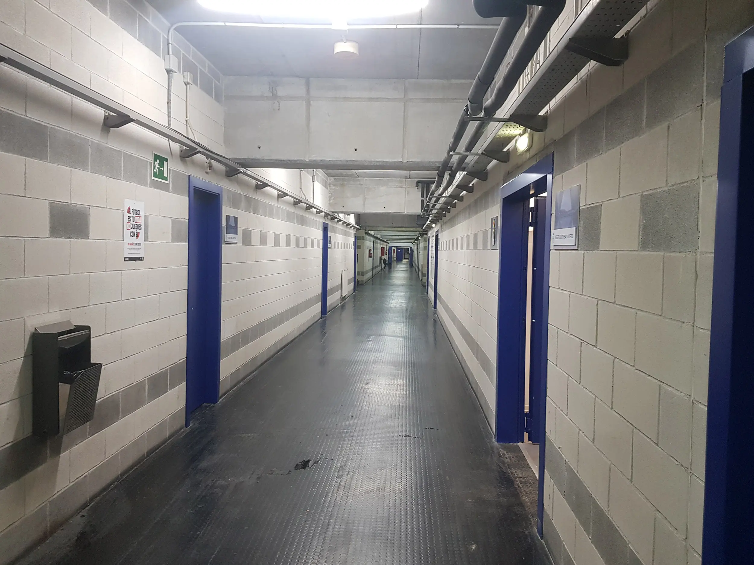 Largo pasillo interior del estadio con diferentes accesos a vestuarios jugadores y árbitros, capilla, sala de prensa y otros