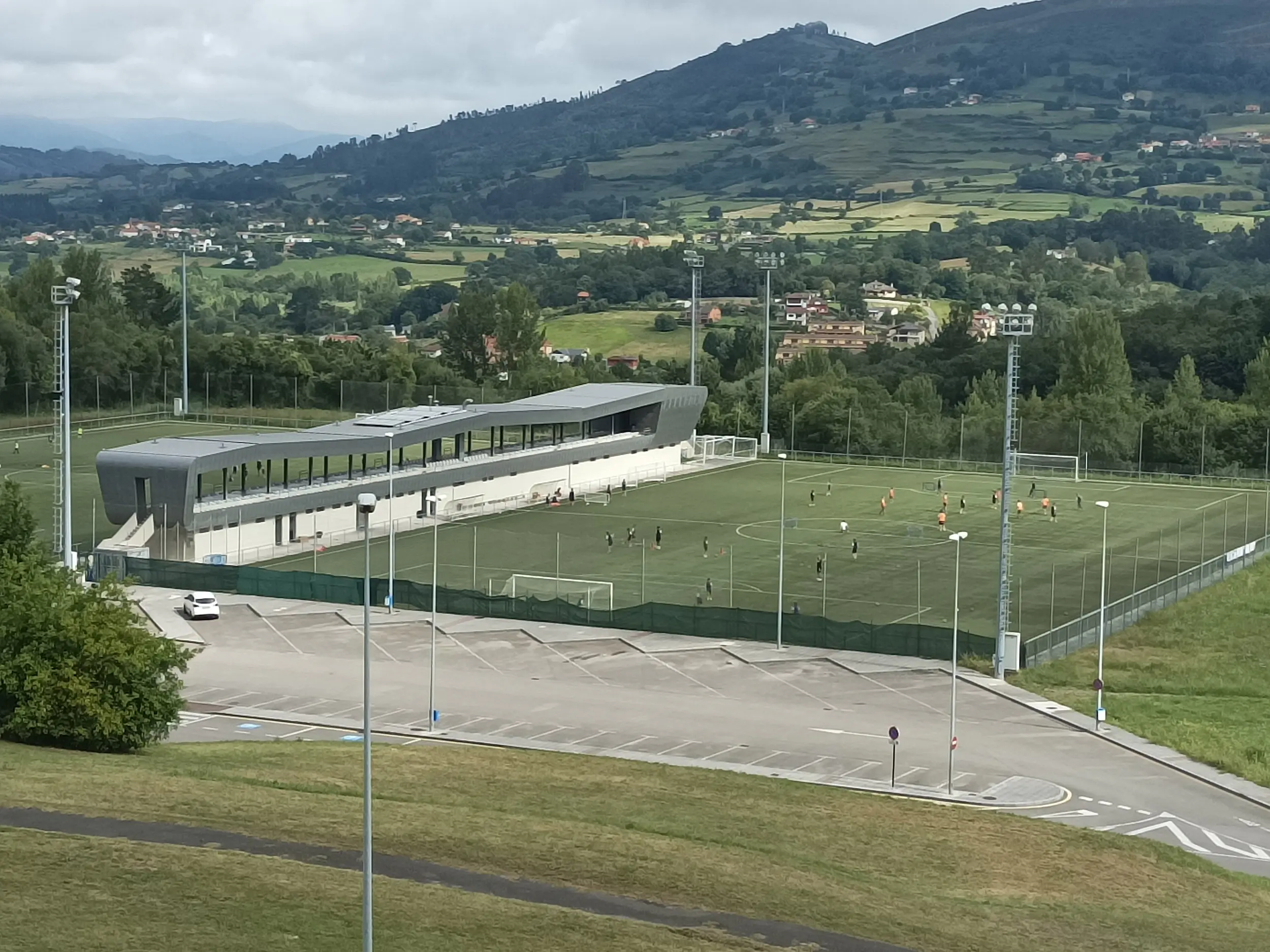 Vista aérea del campo de fútbol 11 de las instalaciones deportivas H. F. E. Tensi, con el aparcamiento y las gradas