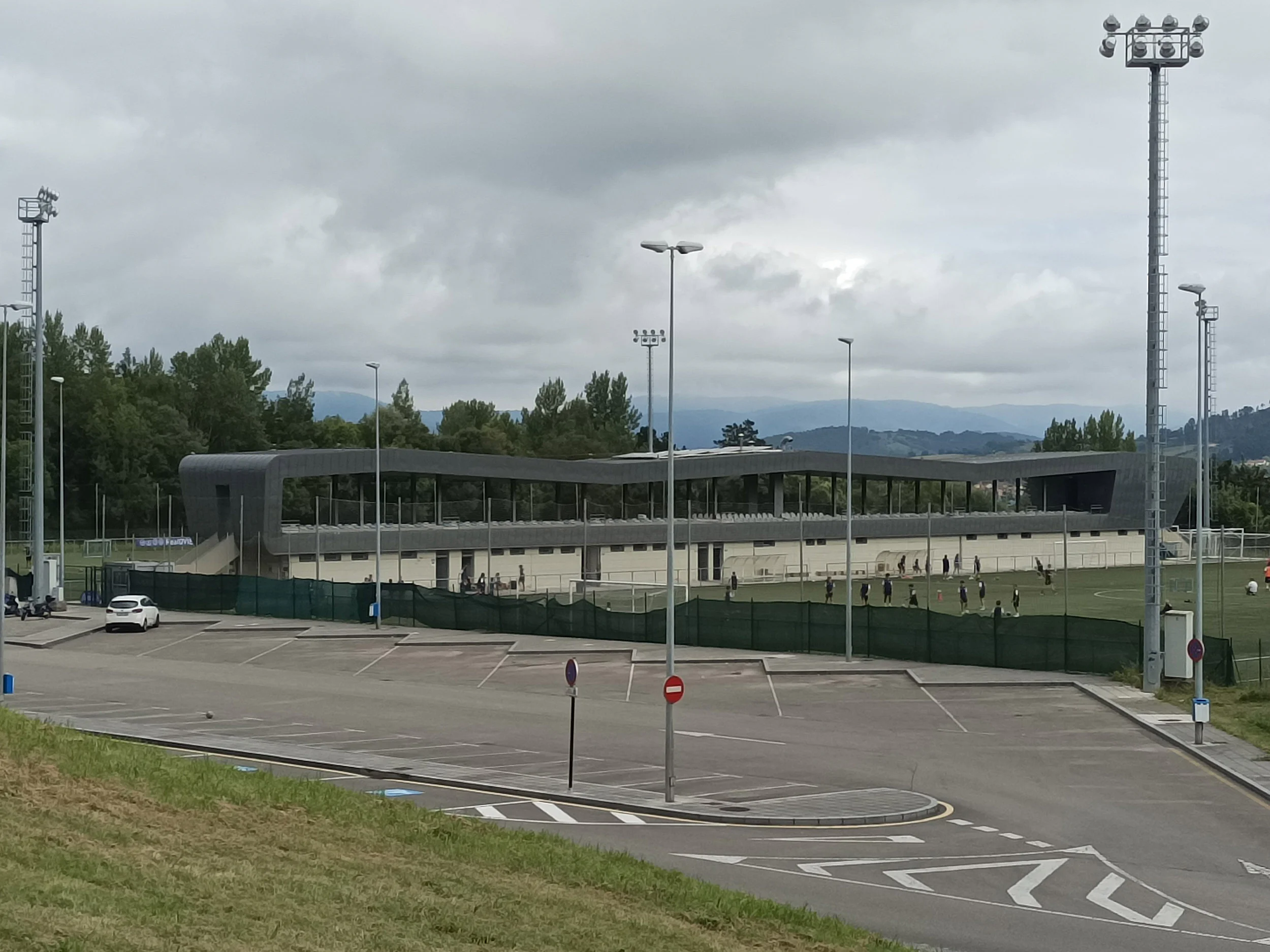 Aparcamientos del campo de fútbol 11, con el campo y las gradas al fondo
