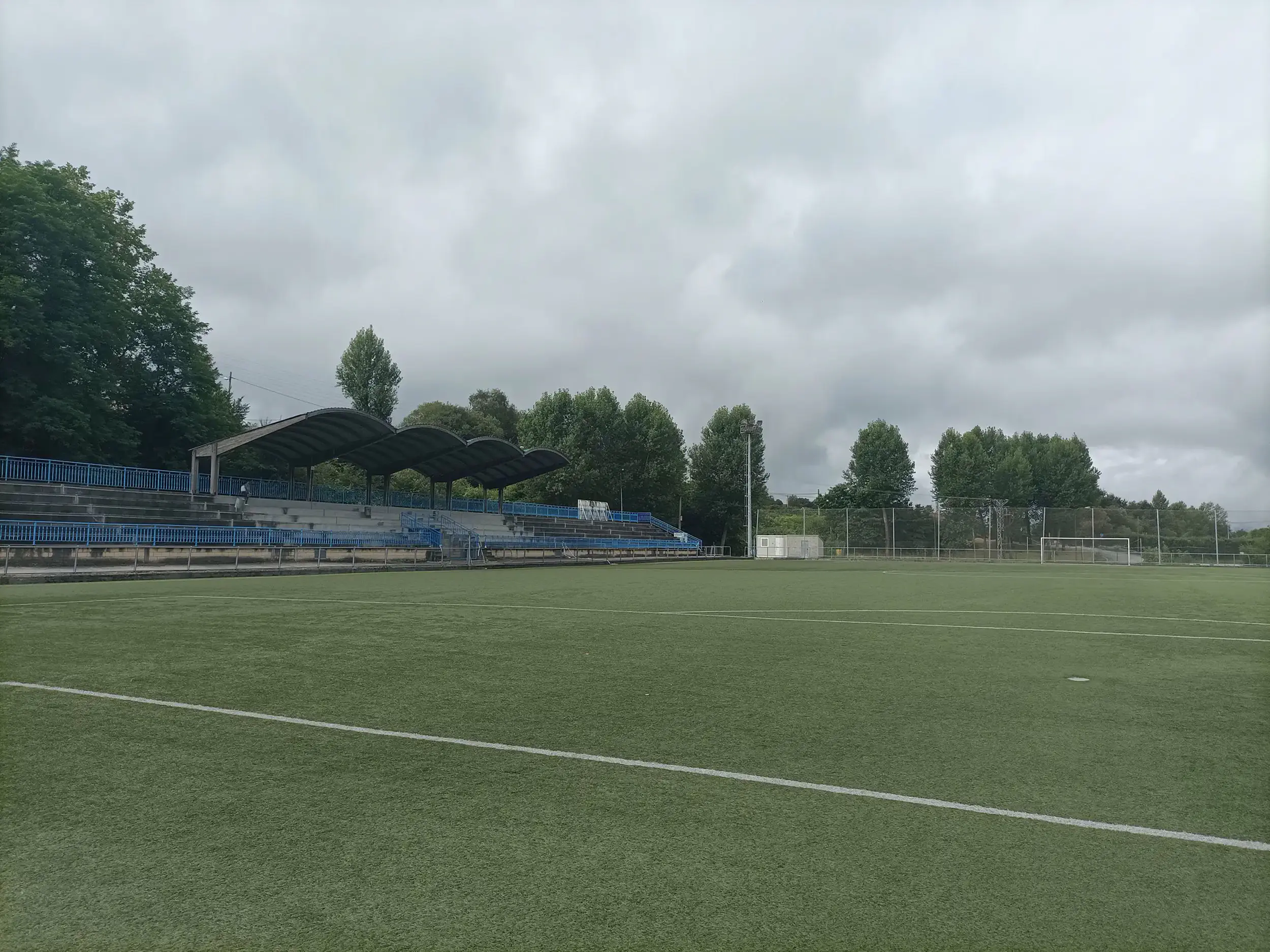 Vista parcial a pie de campo del terrreno de juego, con las gradas cubiertas a un lado y una portería al fondo