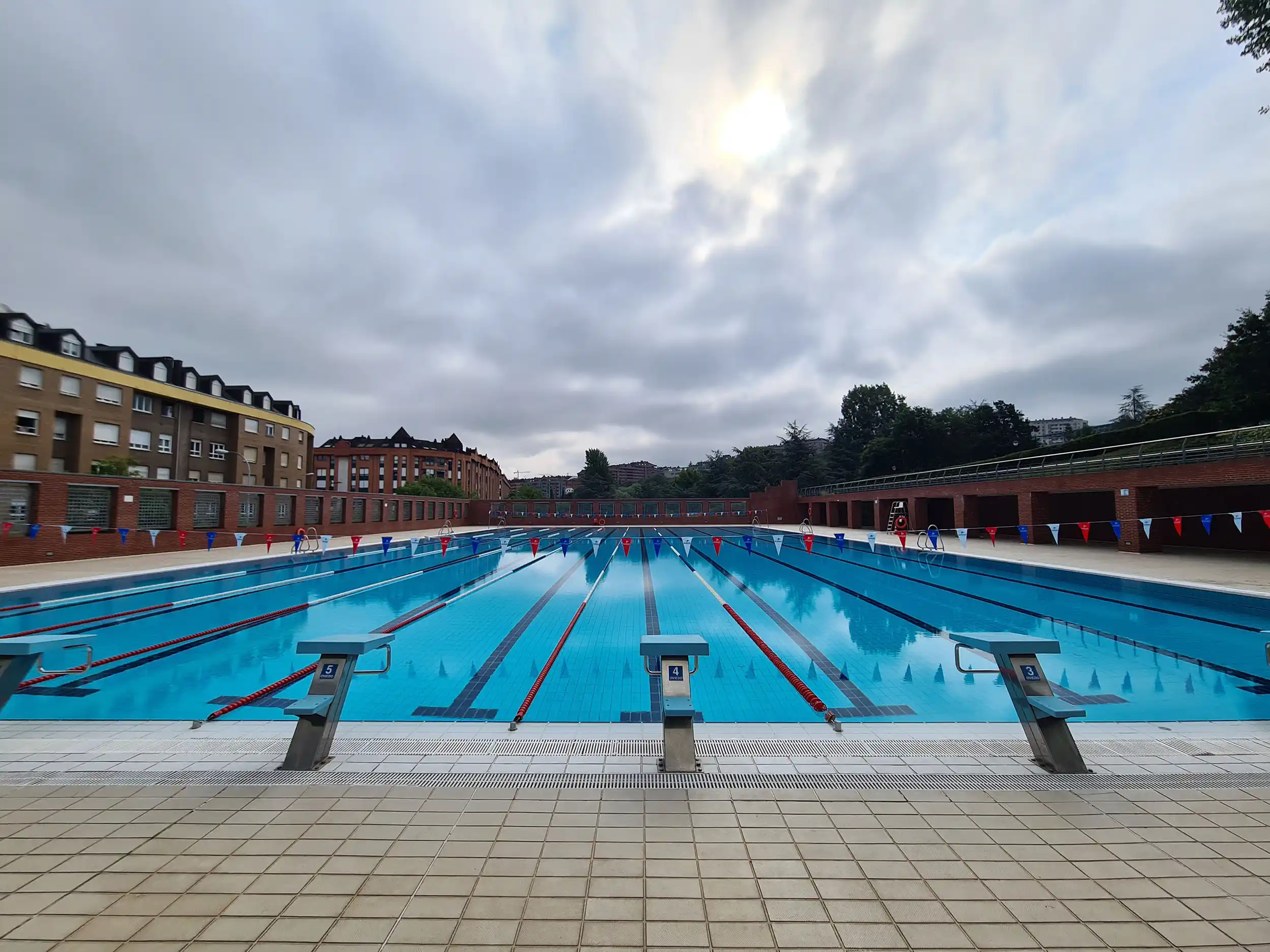 vista de la piscina desde un fondo con los trampolines en primer plano