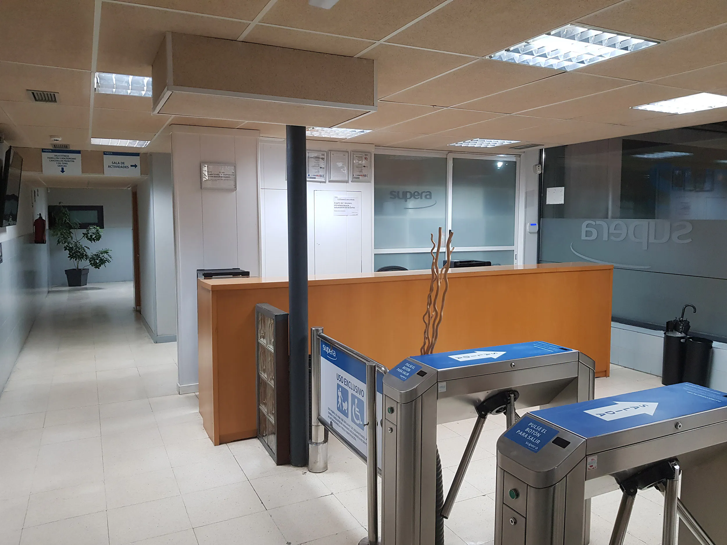 Panorámica de la zona de acceso a las instalaciones, con los tornos automáticos y el mostrador de recepción