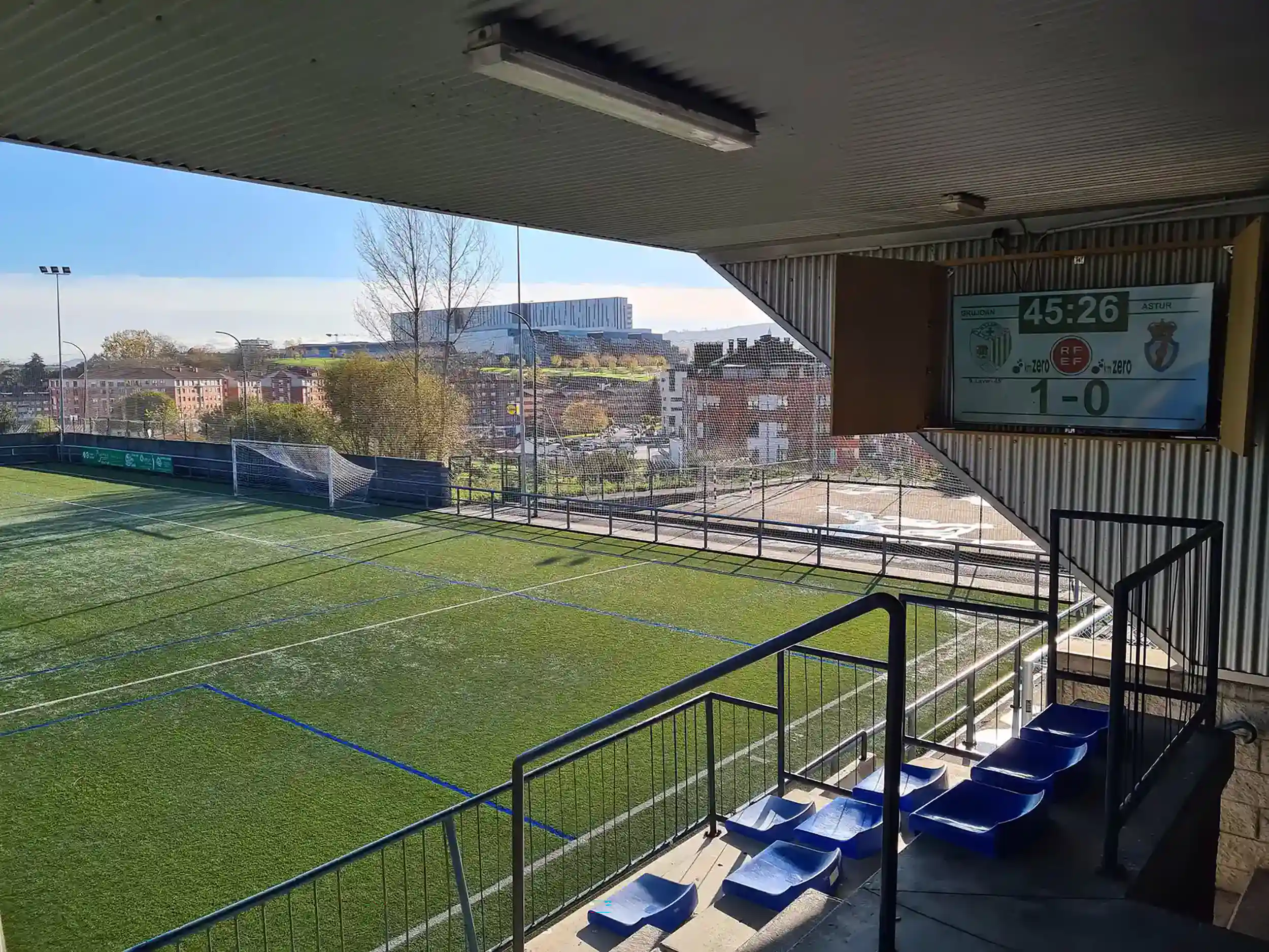 Marcador situado en un muro lateral de la cubierta con gradas azules