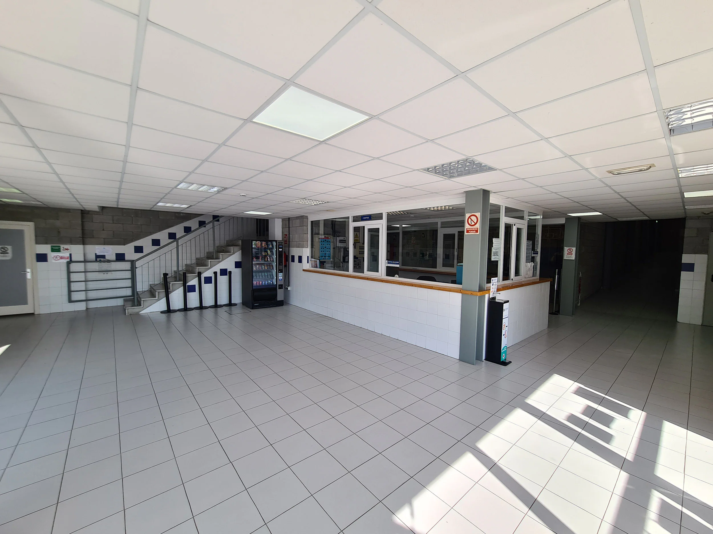 Hall de la entrada principal y recepción del polideportivo, escalera de acceso a planta superior