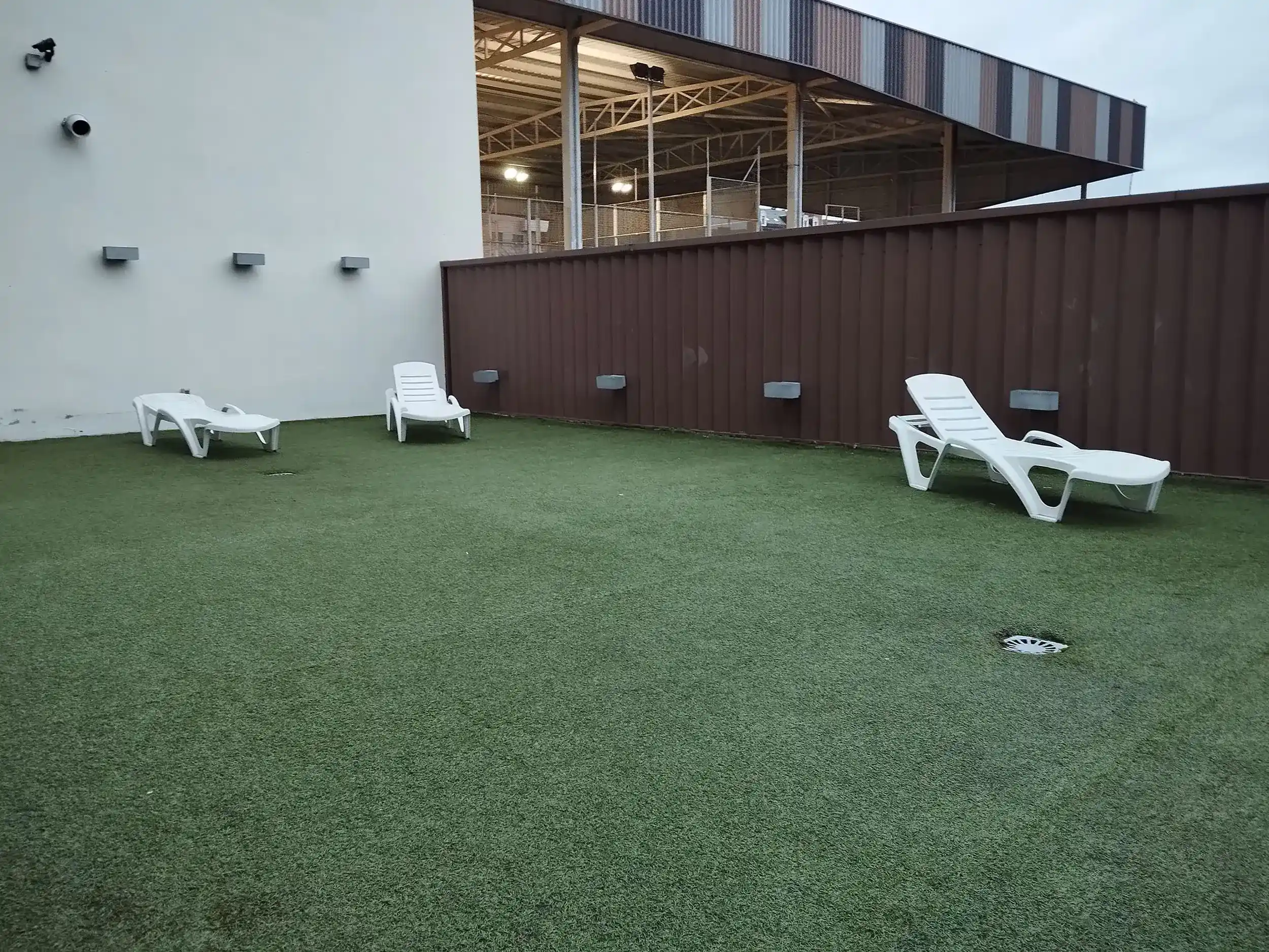 Terraza solárium totalmente descubierta, con piso de moqueta y tumbonas 