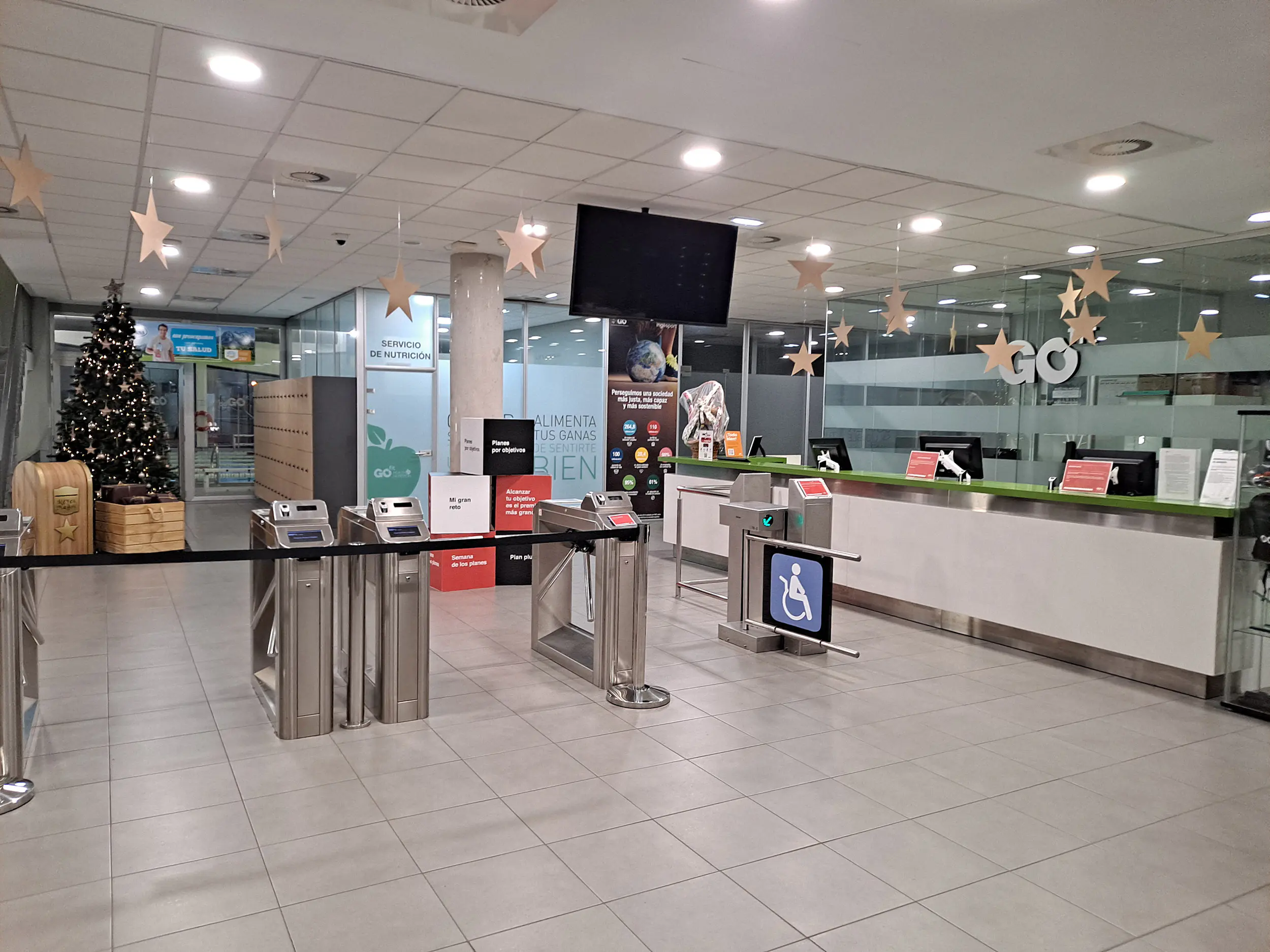 Vestíbulo del centro deportivo, con los tornos de acceso y el mostrador de recepción