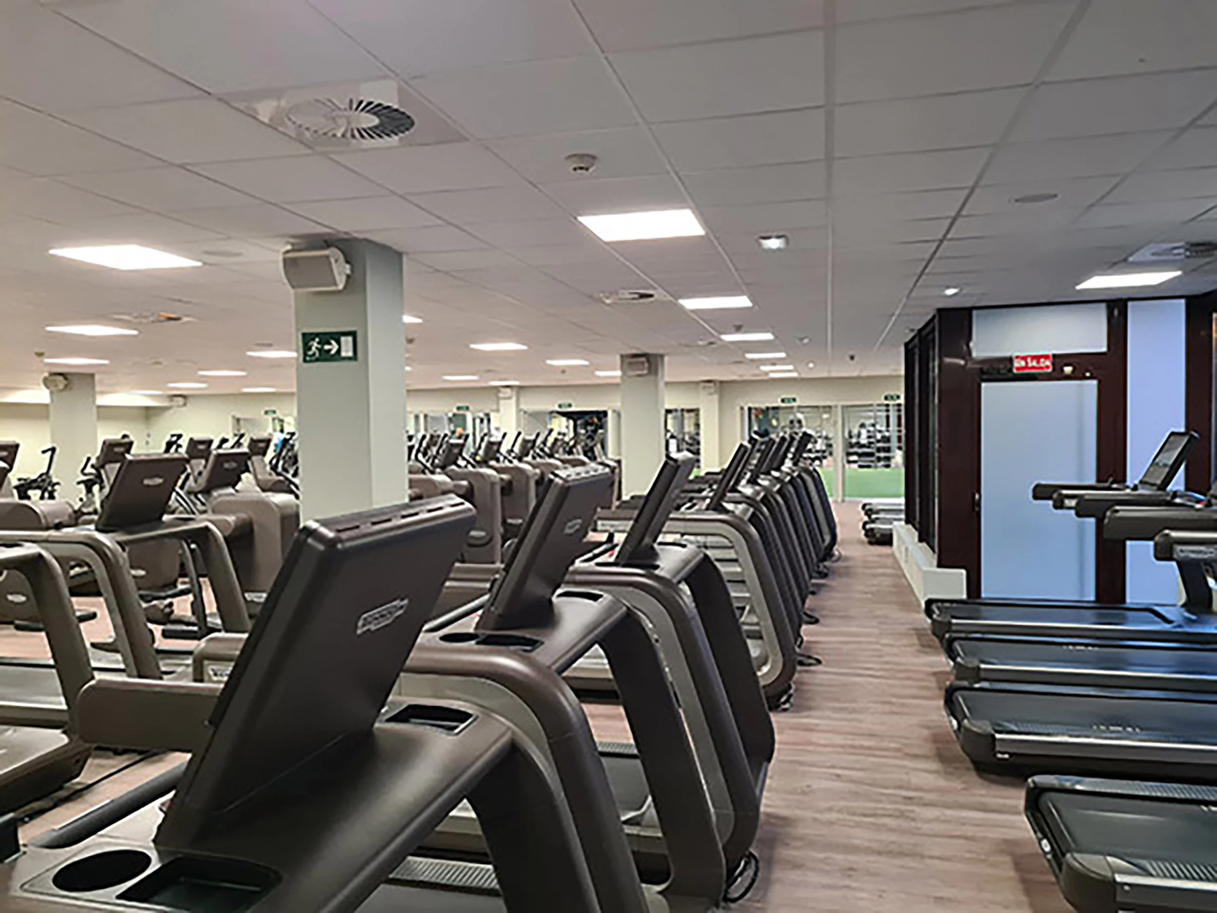 Sala de fitness con varias cintas de correr y ventanas al exterior