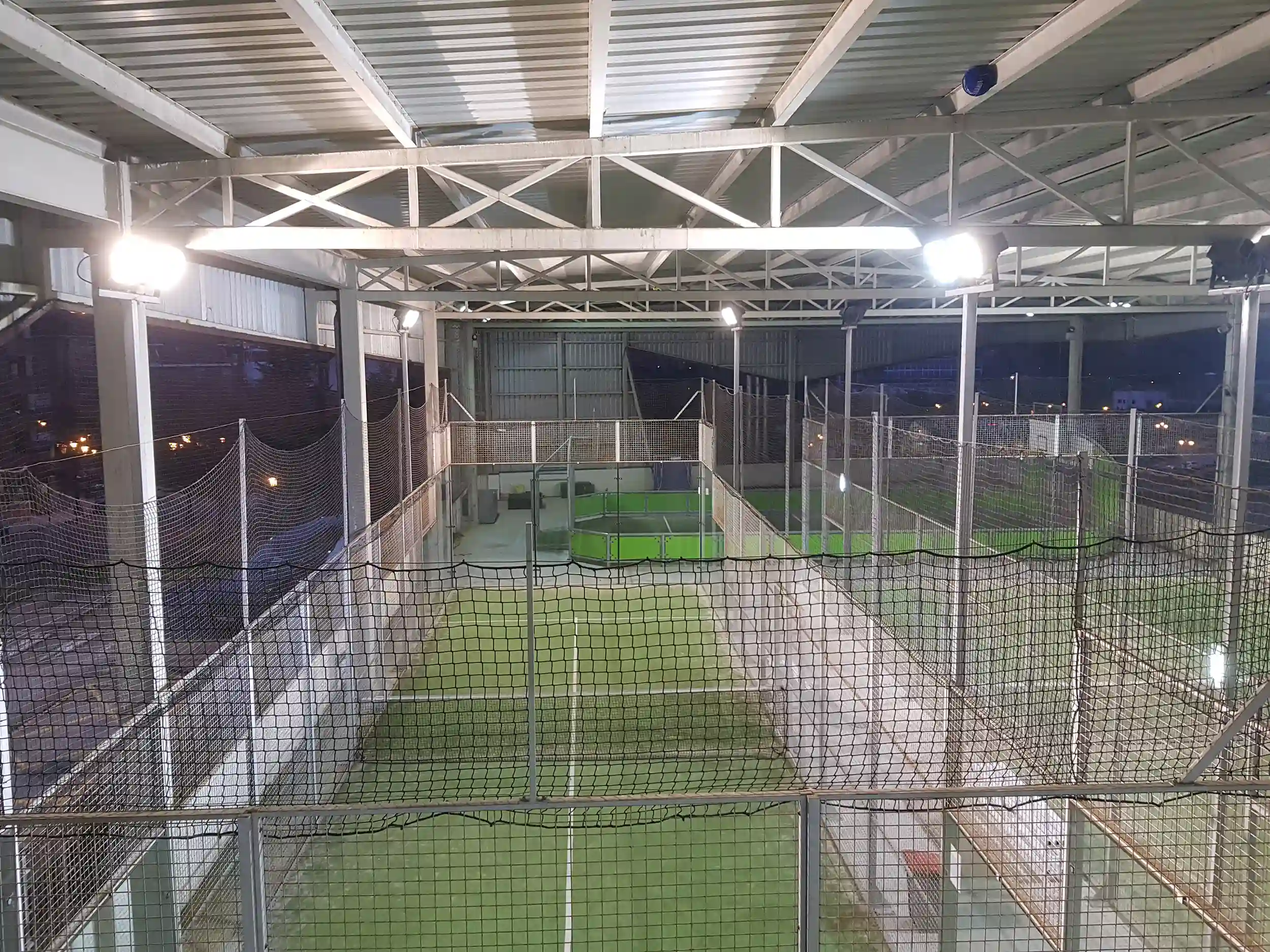 Pista exterior de pádel, cubierta, con vallas de protección e iluminación