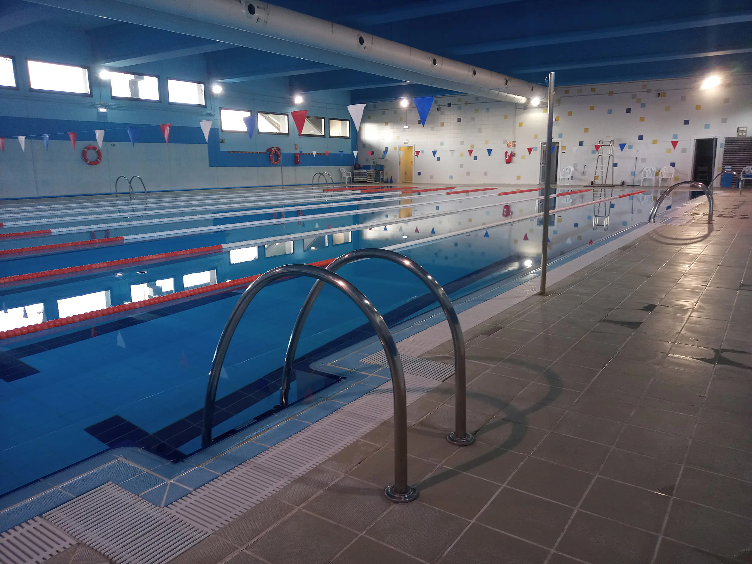 Panorámica lateral de la piscina principal, con vista en detalle de las barandillas de acceso