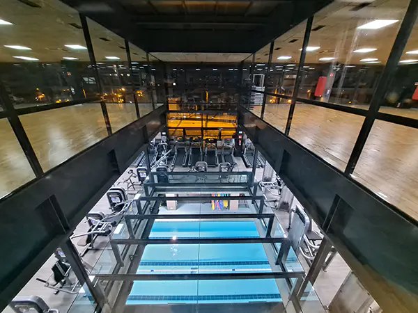 Vista parcial de la sala de fitness y la piscina cubierta, desde la sala de actividades dirigidas del piso superior