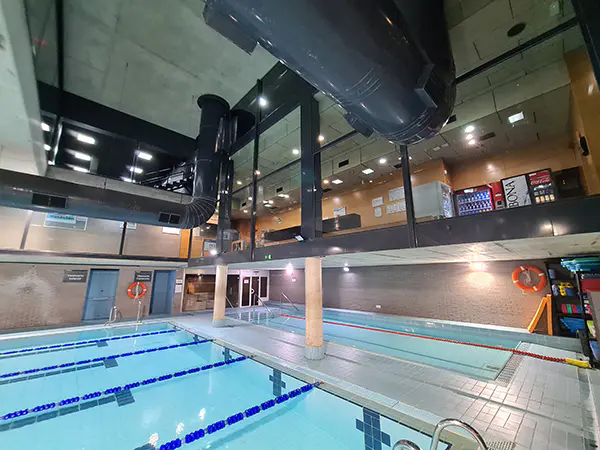 Panorámica de las piscinas climatizadas de entrenamiento y aprendizaje, con vista de la recepción en el piso superior