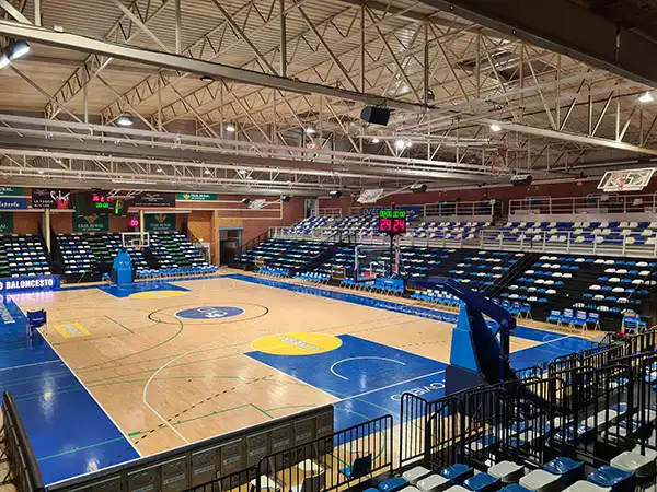 Pista polideportiva y las gradas al fondo y en un lateral de la pista