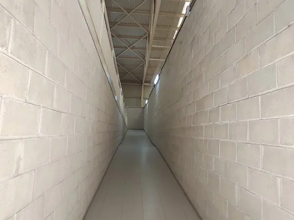 Estrecho pasillo con rampa de acceso a la planta superior del polideportivo