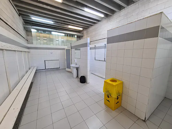 Vestuario y acceso a las duchas. Banco del mismo y acceso a la zona de duchas