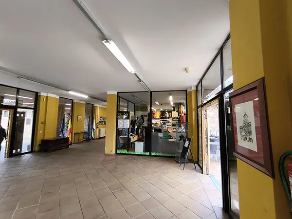 Vestíbulo, con el escaparate de una tienda de artículos de golf y una puerta de salida lateral a la terraza-restaurante