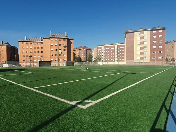 Campo de fútbol desde uno de los córneres, distinguiéndose la práctica totalidad del campo y los banquillos
