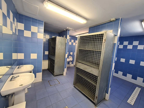 Primer plano de los armarios enrejados de metal del baño alicatado con azulejos en azul y blanco