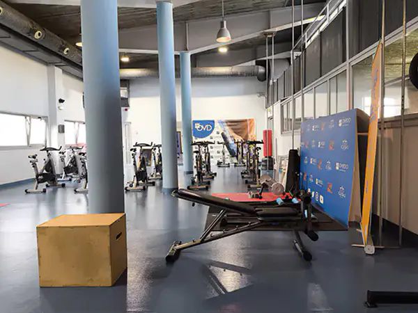 Sala polivalente con bicicletas estáticas y máquinas de ejercicio