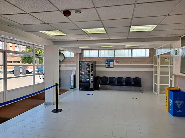 Vestíbulo de la instalación. Fila de asientos y maquina expendedora 