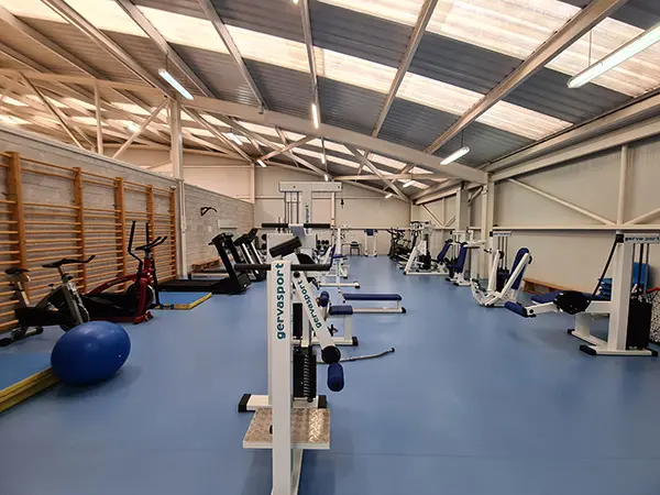 Sala polivalente con aparatos de gimnasia y musculación
