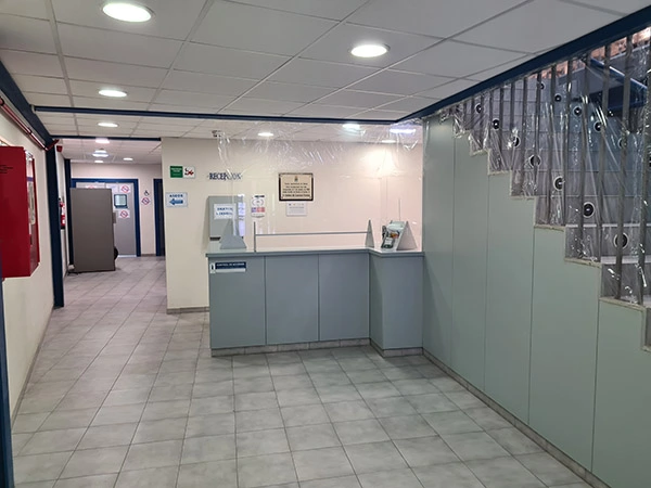 Mostrador de recepción. Escalera para subir a las gradas y pasillo a zona de vestuarios