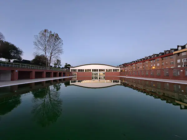 Panorámica de la piscina descubierta de verano, con vista parcial del parque y los edificios circundantes