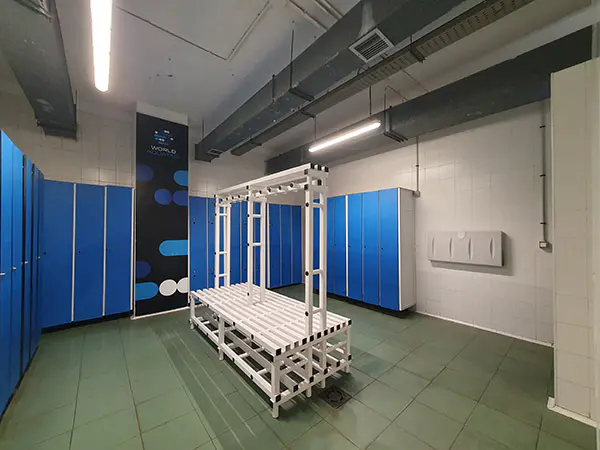 Interior de los vestuarios, con las taquillas y un banco central