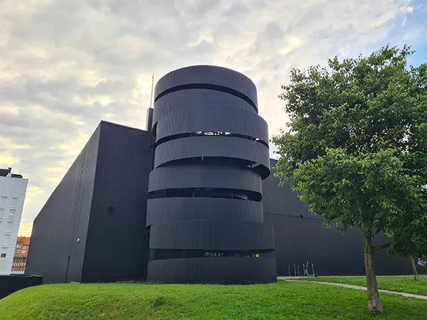 Vista lateral del edificio, con las escaleras exteriores rodeadas de una estructura metálica en espiral