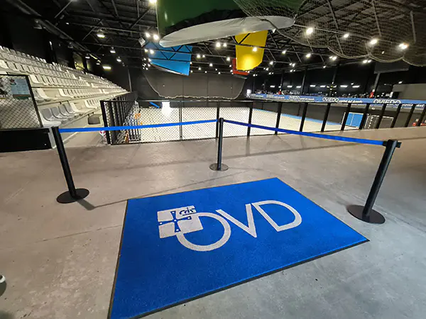 Vista de la zona de gradas y la pista polideportiva. En primer plano, lfombra azul con logotipo del ayuntamiento de Oviedo