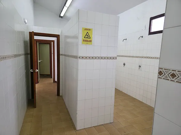 Pasillo de acceso a  los vestuarios con las duchas a la derecha