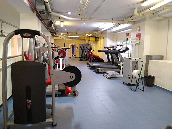 Gimnasio interior, con cintas de correr y diversas máquinas de equipamiento deportivo